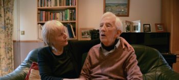 Older woman offers comfort to elderly confused man