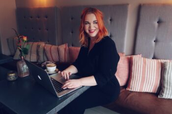 Young woman working on a laptop computer with a coffee