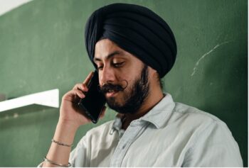 Man with neutral expression is making a call, on the phone to the mental health helpline